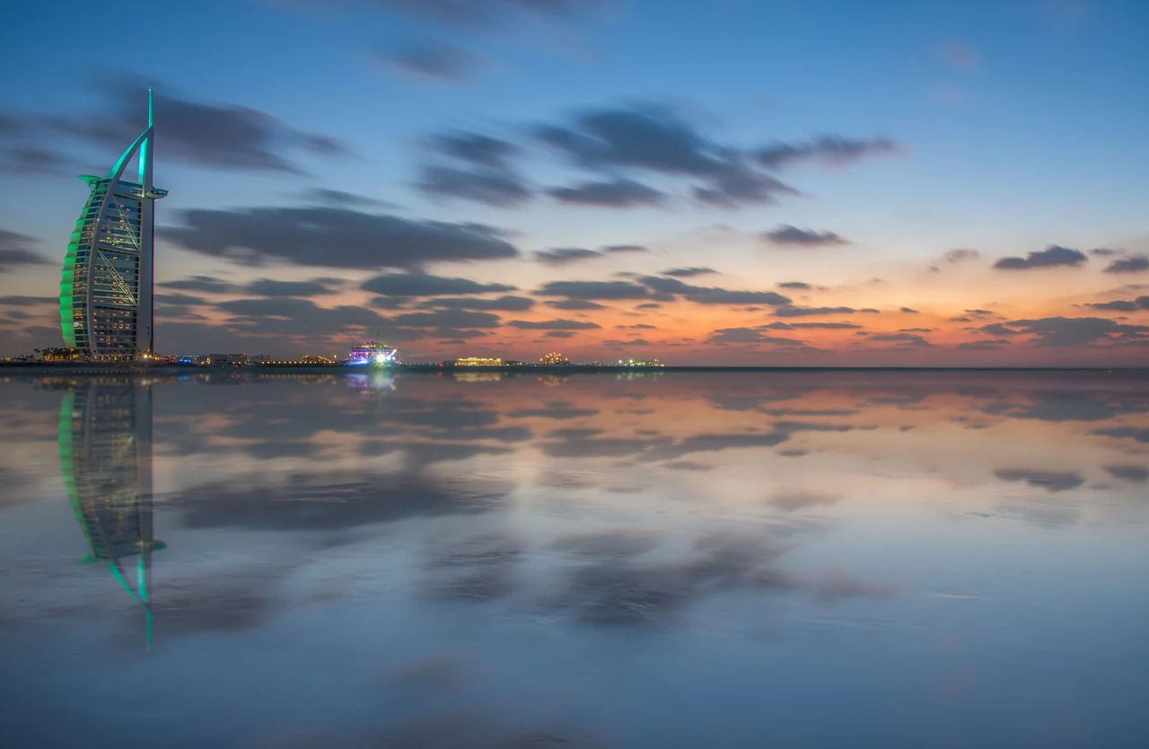 Burj Al Arab and its reflection on the water at dusk