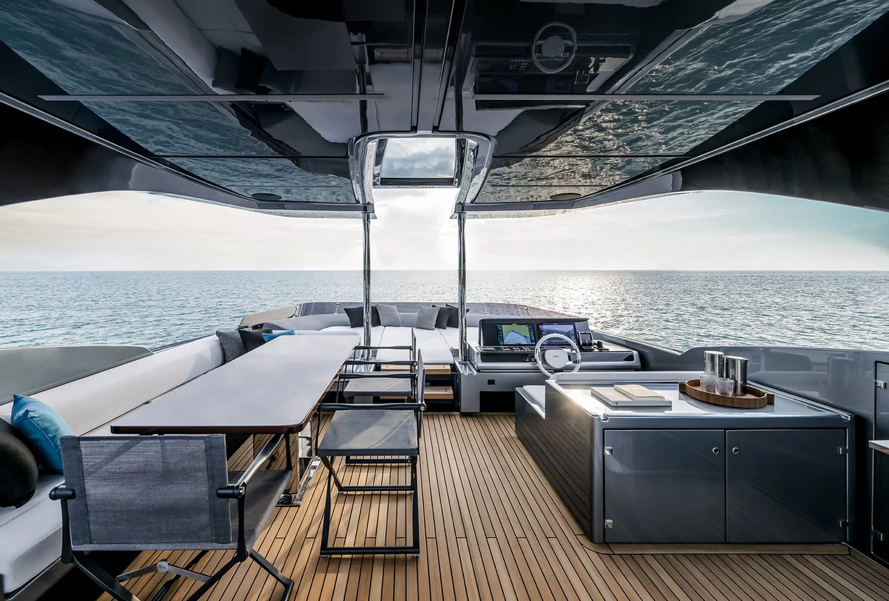 Flybridge lounge and table beneath a hardtop on Riva 82